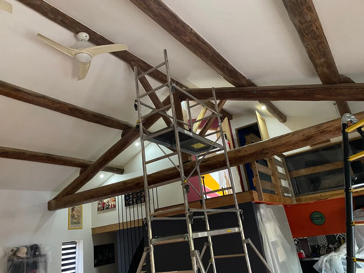Intérieur avec échafaudage installé pour un traitement professionnel du bois contre les insectes.